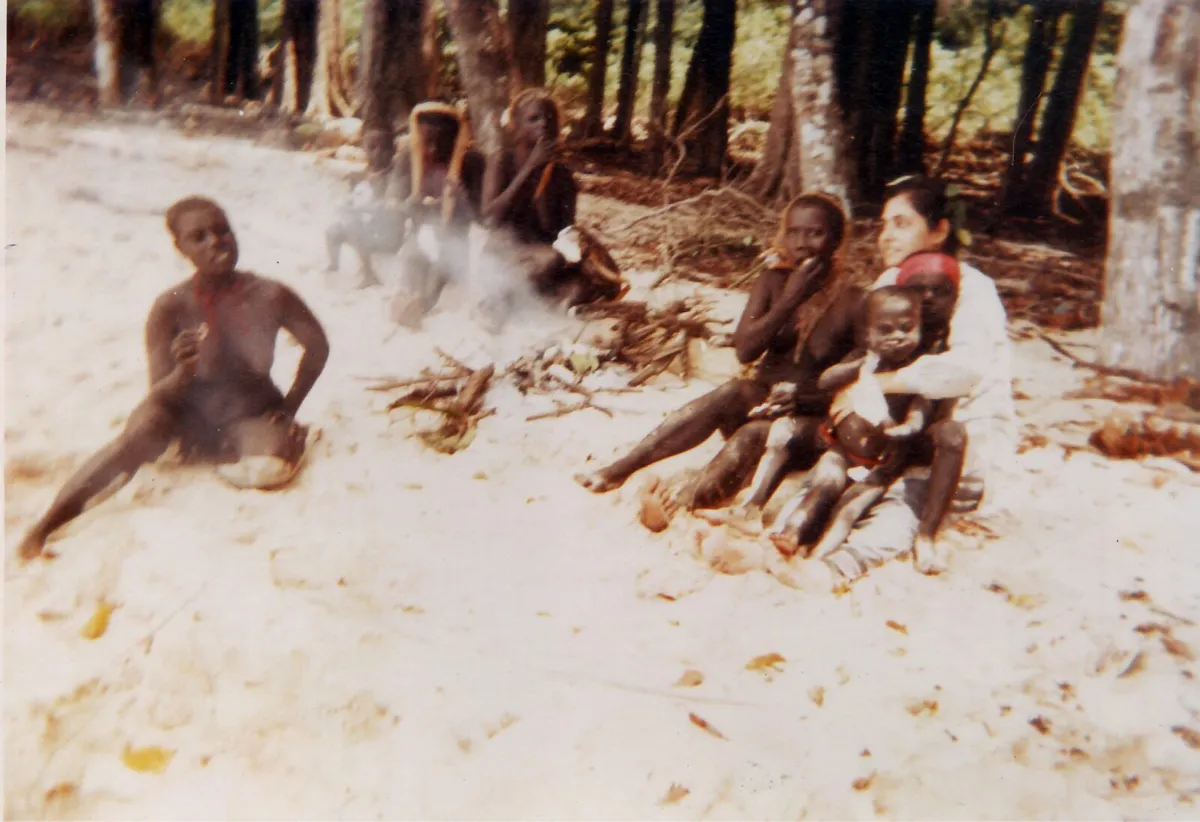 Living the anthropologist's dream. With a couple of Jarawa children sitting on her lap, Madhumala shares roasted green banana and coconut with community members